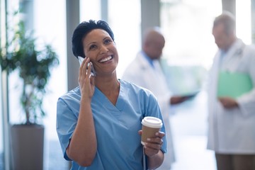 Female doctor talking on mobile phone - Powered by Adobe