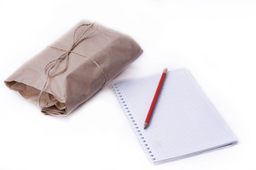 Package, notebook and pencil on white background