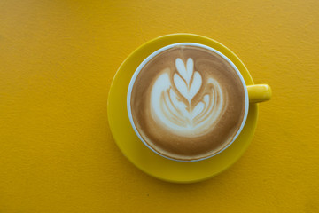 A Cup of hot latte art coffee on wooden table