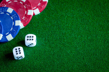 poker chips and dice on green background top view