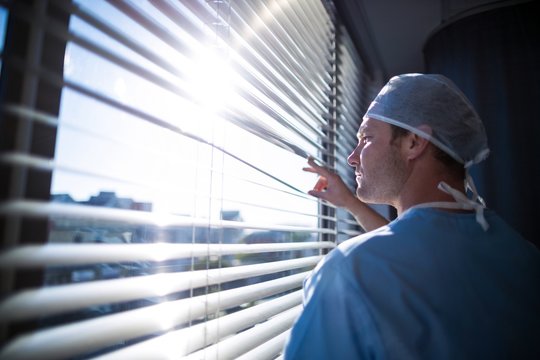 Doctor looking through window