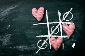 Tic Tac Toe Game. Love or Valentine's Day Concept with Chalkboar