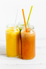 Fresh detox juices in glass bottles on white background