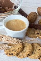 Cup of coffee, cookies, walnut and chocolate on the white wooden background
