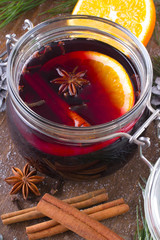 Christmas drink with orange fruit, anise, cinnamon and cloves on wooden table