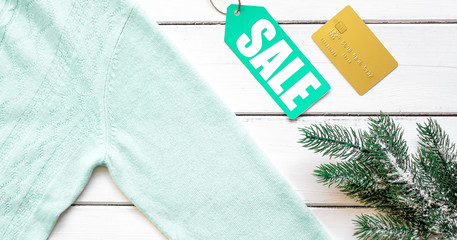 winter clothing sale on wooden background top view
