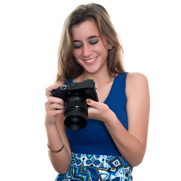 Pretty teenage girl looking at pictures on the rear display of a professional camera - Isolated on white