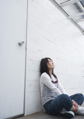 Teenage girl leaning against wall