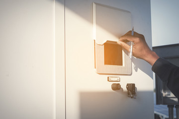 engineer or electrician working on checking and maintenance equipment at green energy solar power plant: checking status inverter
