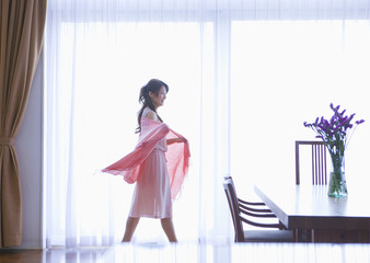 Young woman standing by the window