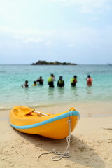 Yellow kayak on beach in evening day with blue sea background.