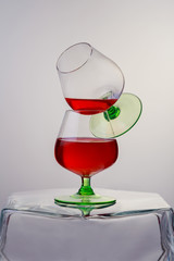 Two glasses of brandy or cognac and bottle wooden table.