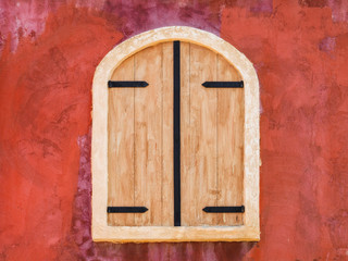Window in the stone wall with wooden blinds