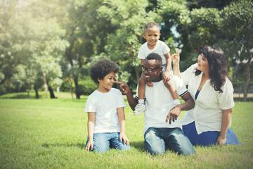 African American family alongside with Asian mum being playful and having good times in the park