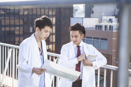 Doctors talking while watching CT images on the hospital's rooftop