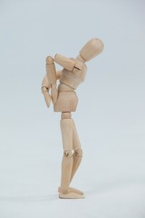 Wooden figurine standing with hands on back