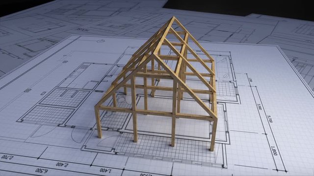 Wood frame making house on architectural design plan paper.