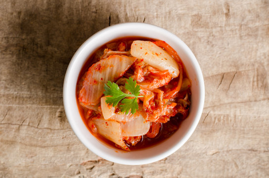 Kimchi cabbage (Korean food) in a bowl on wooden background