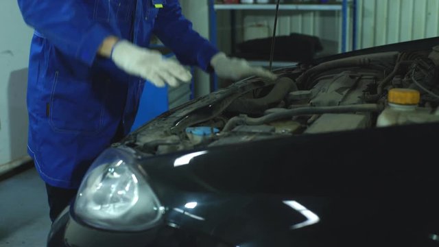 Hands of car mechanic in auto repair service.