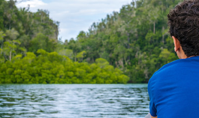 Traveler looking into Mangrove Jungle near Warikaf Homestay, Kabui Bay and Passage. Gam Island, West Papuan, Raja Ampat, Indonesia