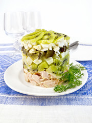 Salad of chicken and kiwi on blue tablecloth
