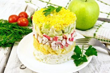 Salad of crab sticks and apple on light board