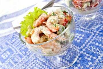 Salad with shrimp and avocado in glass on tablecloth