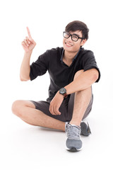 Young man sitting on the floor, pointing and looking to his side