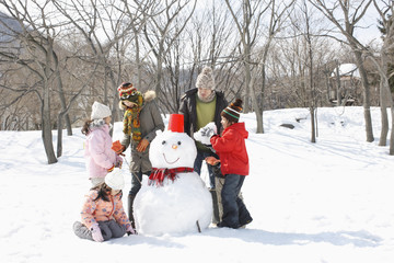 Fototapeta na wymiar Family making a snowman