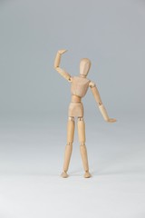 Wooden figurine standing with hand raised