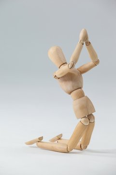 Wooden figurine kneeling with both hands joined