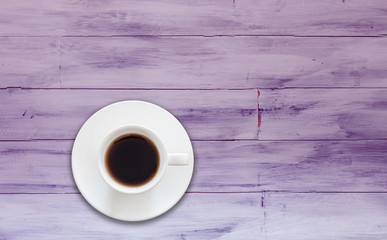 Top view of coffee cup on purple wooden background