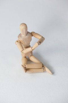 Wooden figurine performing yoga on floor