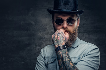 Bearded male in sunglasses and cylinder hat.