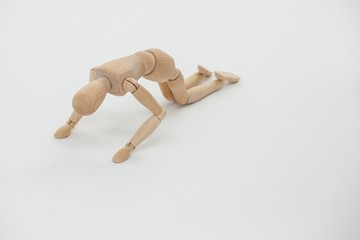 Wooden figurine exercising on floor