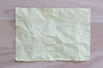 Yellow notepad paper crumpled of empty and copy space on wooden
