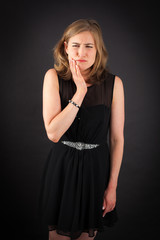 Fototapeta premium Beautiful woman doing different expressions in different sets of clothes: toothache