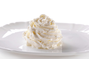 Whipped cream on porcelain plate close-up on white background 
