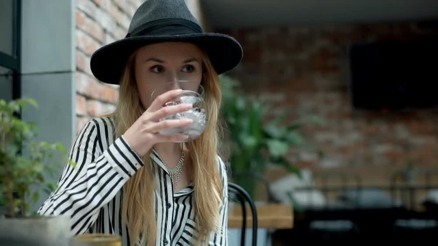 Elegant woman relaxing in the cafe and drink fancy beverage
