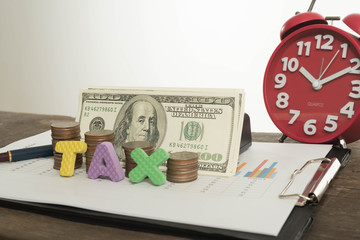 Tax Concept with wooden block on stacked coins