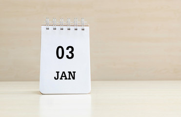 Closeup surface note book with black 3 jan word in page on blurred brown wood desk and wood wall textured background with copy space under window light