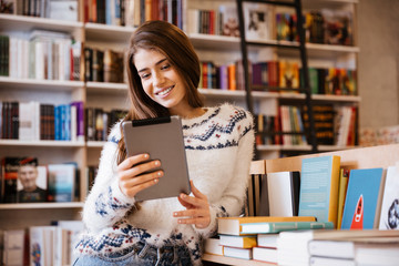 Woman with tablet in library