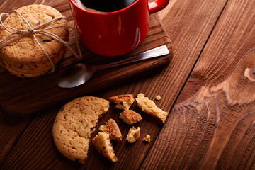 Coffee and Homemade cookies with chocolate. Handmade Chocolate cookies and cup of espresso on wooden table. Pile of delicious chip cookies. Christmas cookies. Biscuits. Oat biscuits.
