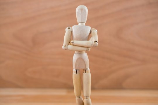 Wooden figurine standing with arms crossed - Powered by Adobe