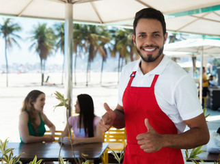 Lachender Kellner an der Strandbar