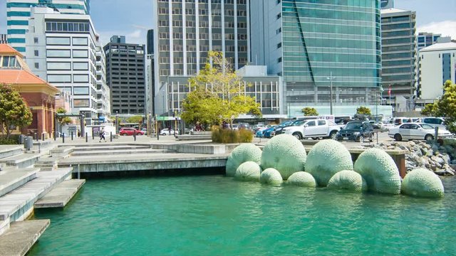 Wellington NZ City Center Waterfront Artwork of Green Shells Submerged in Water with Downtown Scene in Background