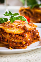Piece of tasty hot lasagna with red wine.. - obrazy, fototapety, plakaty