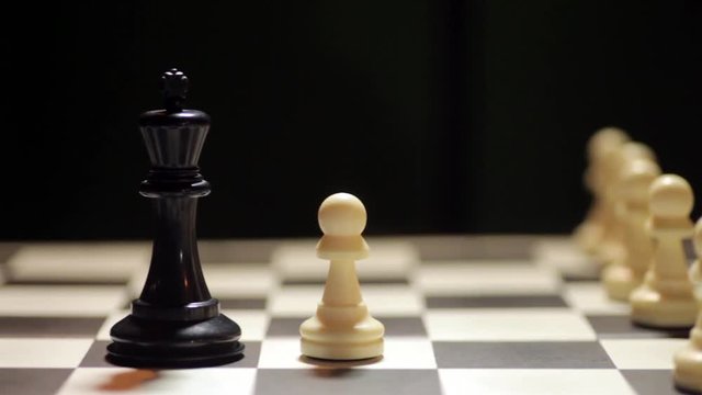 Panning shot of a chess board, with white pawn conquering the black king.
