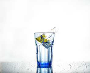 Splash of water with ice and lemon in a glass