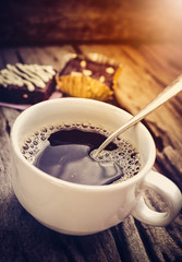 Cake chocolate brownie and hot coffee on old wooden background.